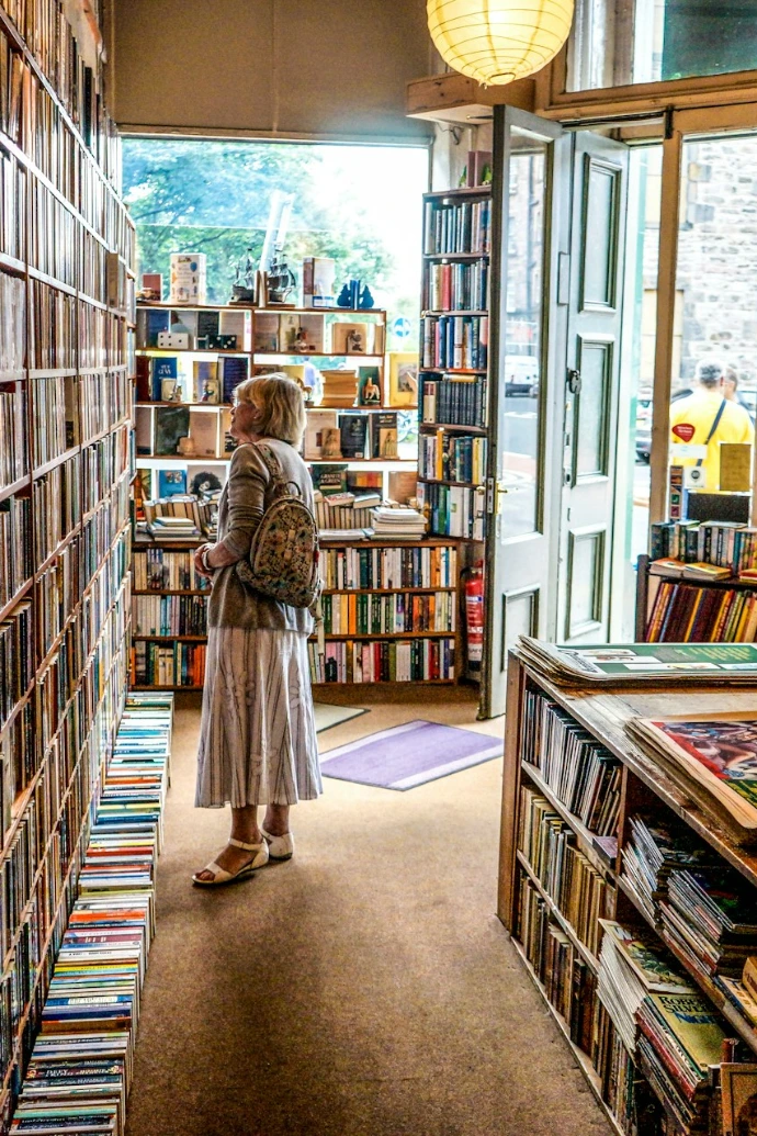 woman inside library looking at books